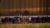 Migrantes cerca del muro fronterizo después de cruzar el río Bravo con la intención de entregarse a los agentes de la Patrulla Fronteriza de los Estados Unidos. (REUTERS: José Luis González).