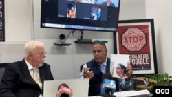 Rolando Cartaya, de la Fundación para los Derechos Humanos en Cuba (izq.), escucha a Samuel Rodríguez denunciar a la jueza Melody González como una represora del régimen de La Habana, este martes 27 de agosto de 2024 durante una conferencia de prensa.