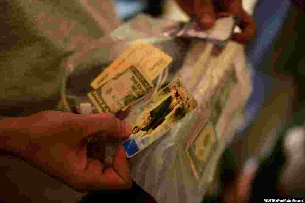 Un cubano solicitante de asilo muestra sus pertenencias que le devolvieron después de pasar días en detención migratoria en un hotel utilizado como albergue en Deming, New Mexico, el 30 de marzo de 2022