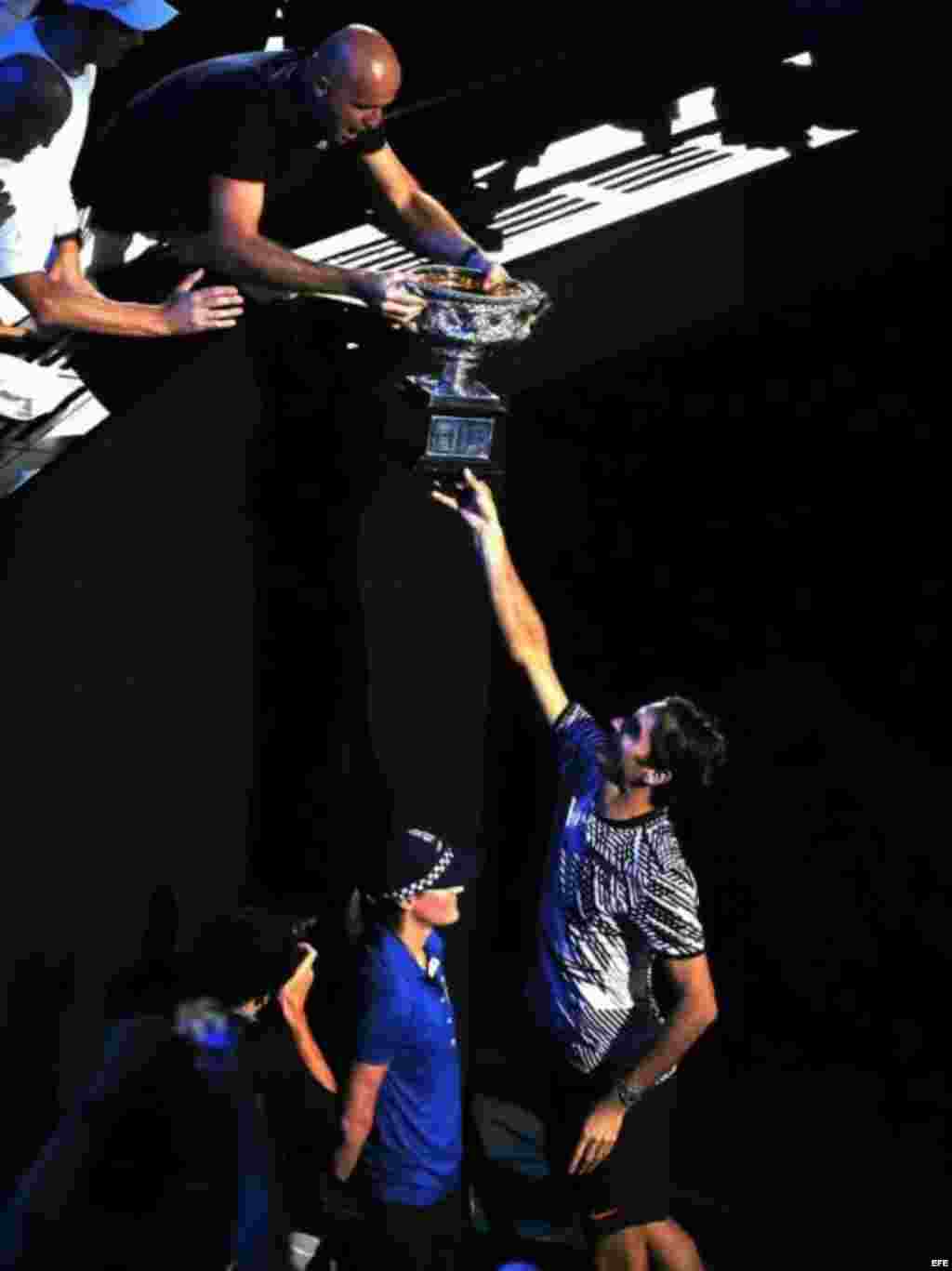 Roger Federer le entrega el trofeo a su entrenador Ivan Ljubicic tras vencer a Rafael Nadal en la final masculina en el torneo de tenis Grand Slam de Melbourne, Australia, el 29 de enero de 2017.  