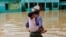 Un hombre lleva a su nieta en la espalda en un área inundada en la zona de Feni, Bangladesh. REUTERS/Mohammad Ponir Hossain