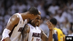 Chris Bosh (i) de los Miami Heat habla con Mario Chalmers.