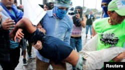 Manifestantes ayudan a un hombre herido durante una protesta contra el Gobierno del presidente de Nicaragua, Daniel Ortega, en Managua, Nicaragua, el 21 de enero de 2019.