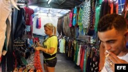 Una mujer organiza la mercancía en un pequeño negocio privado de venta de ropa importada en La Habana (Cuba). El Gobierno de Cuba ordenó hoy el cierre de las salas privadas de cine 3D que han proliferado en la isla en el último año, al tiempo que puso un