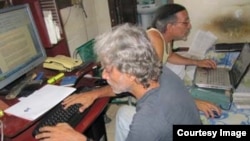 Febles, atrás, y su colega Luis Cino trabajan en la redacción de Primavera Digital.