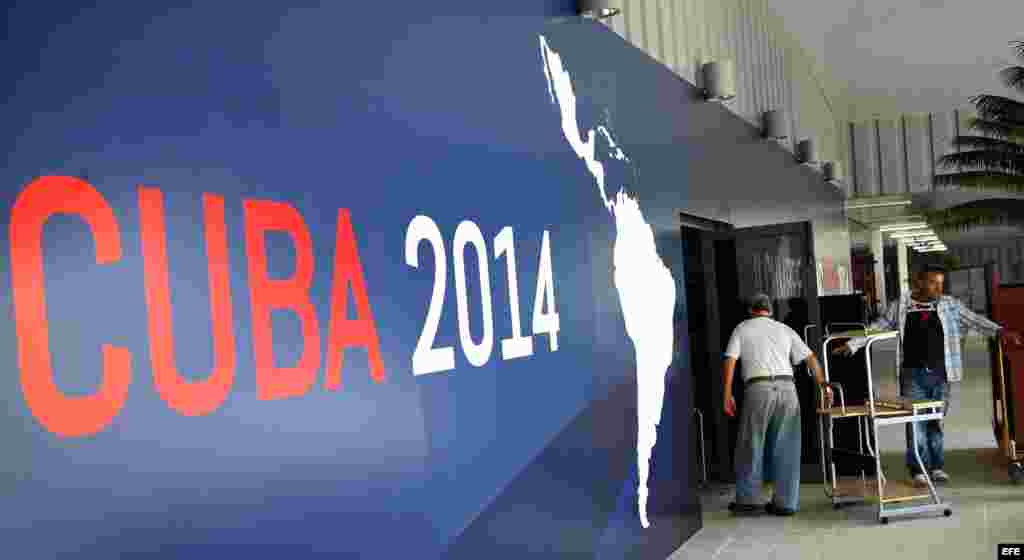 Dos hombres ingresan muebles al salón principal de Pabexpo, sitio donde se celebrará próximamente la II Cumbre de la Comunidad de Estados Latinoamericanos y del Caribe (CELAC).