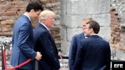 El primer ministro canadiense, Justin Trudeau, los presidentes estadounidense, Donald Trump (2º izq), y galo, Emmanuel Macron, y el presidente del Consejo Europeo, Donald Tusk (dcha, detrás), conversan tras posar para una foto de familia durante la cerem