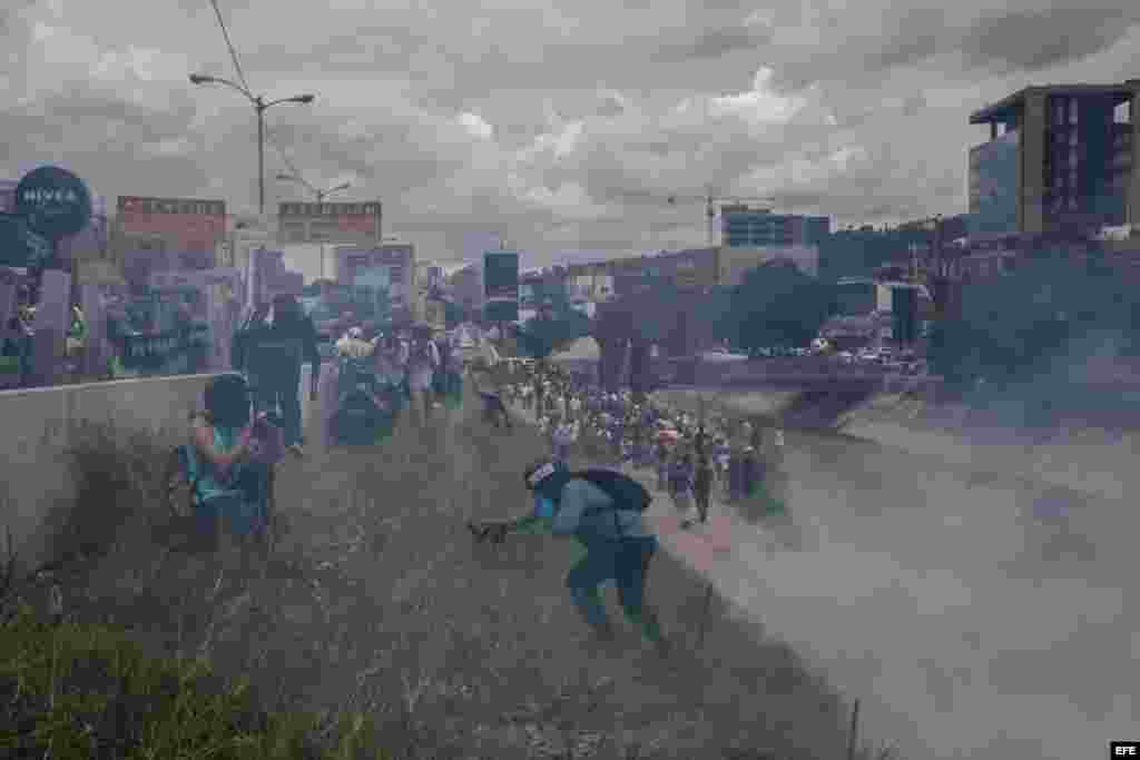 Manifestación donde un grupo de personas corre tras intentar tomar una autopista en la ciudad de Caracas (Venezuela).